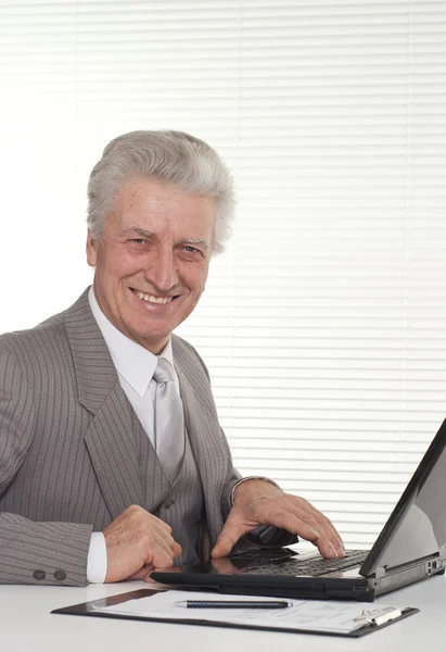 Un uomo anziano seduto al portatile — Foto Stock