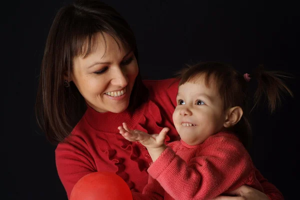 En smuk kaukasisk lyksalighed mor holder sin datter i hendes arme - Stock-foto