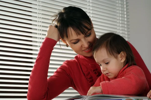 En vacker kaukasiska lycka mor och dotter anläggning bok — Stockfoto
