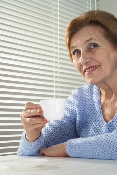Güzel beyaz yaşlı kadın ile bir fincan — Stok fotoğraf