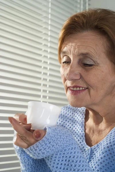 Bela caucasiana desfrutar de mulher idosa com um copo — Fotografia de Stock