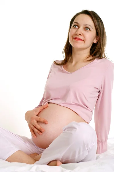 Счастливая беременная женщина сидит — стоковое фото