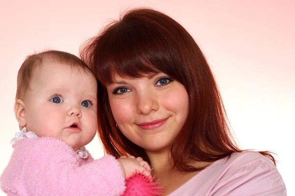 Beautiful charming mother holds her daughter in her arms — Stock Photo, Image