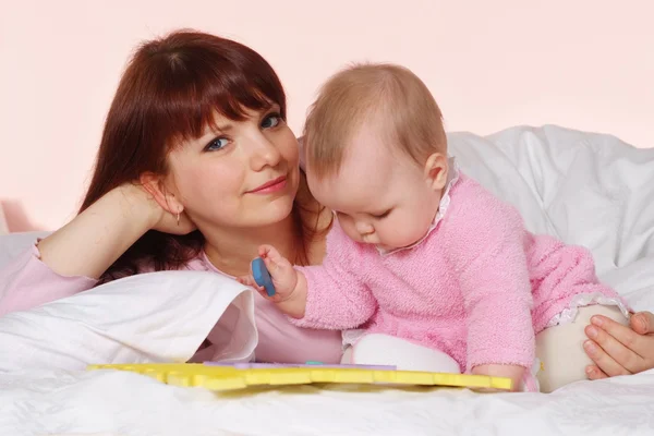 Beautiful attractive mother and daughter lying — Stock Photo, Image
