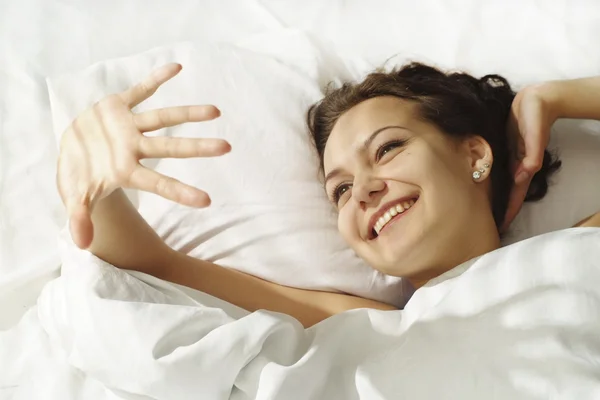 Счастливая девушка лежит в постели — стоковое фото