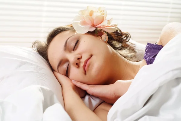 Красивая кавказская девушка с цветком в постели — стоковое фото