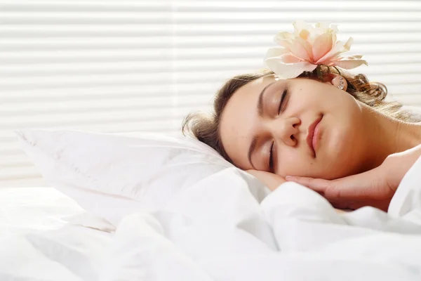 Krásná kavkazské štěstí dívka s květinou v posteli — Stock fotografie