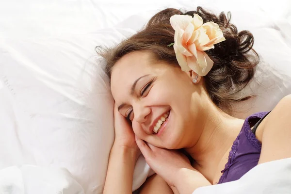 ベッドで花を持つ美しい白人女性 — ストック写真