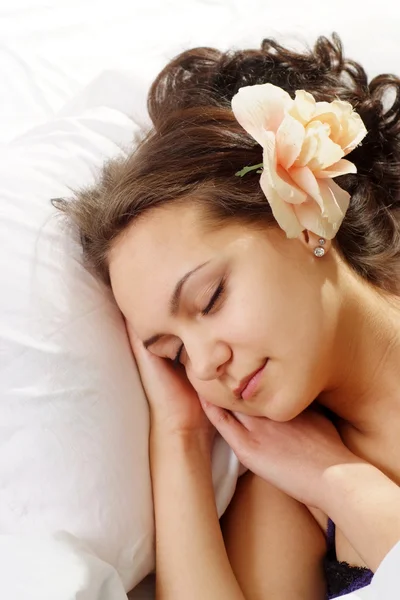 Güzel beyaz mutlu bir kadın yatakta çiçek — Stok fotoğraf