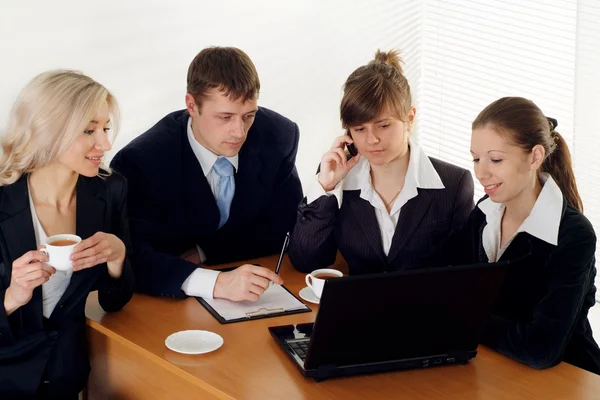 A team of four sitting at a table — Stock Photo, Image