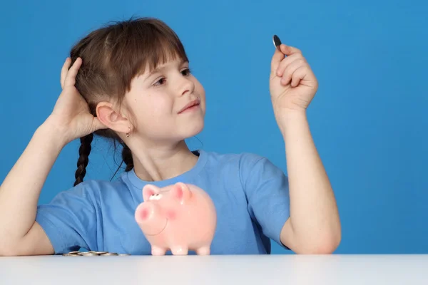 The little girl looks at a penny — Stock Photo, Image