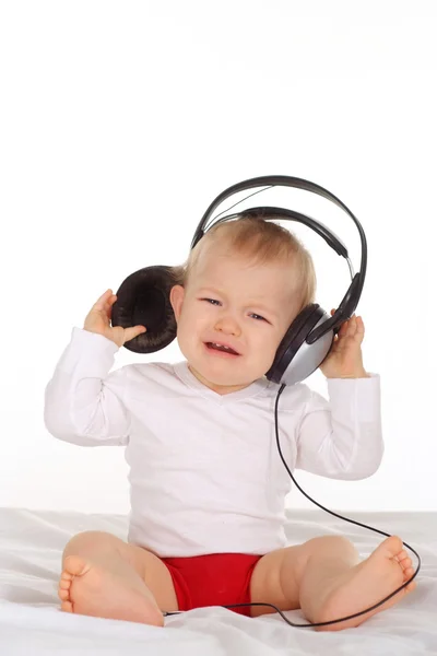 Маленький ребенок слушает музыку через — стоковое фото
