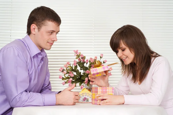 Joy Caucasian guy and his girlfriend are sitting at a table — Stock Photo, Image
