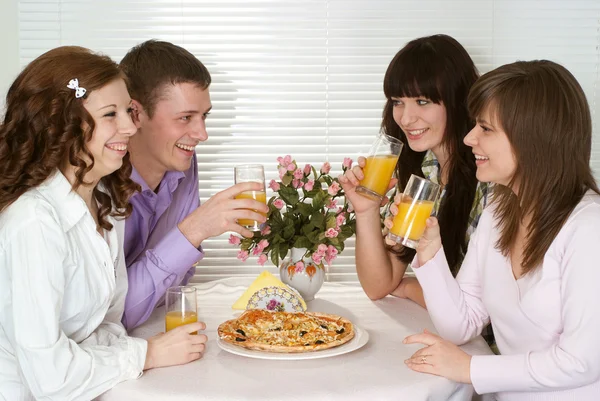 Grupo caucasiano agradável de quatro com pizza e suco sentar — Fotografia de Stock