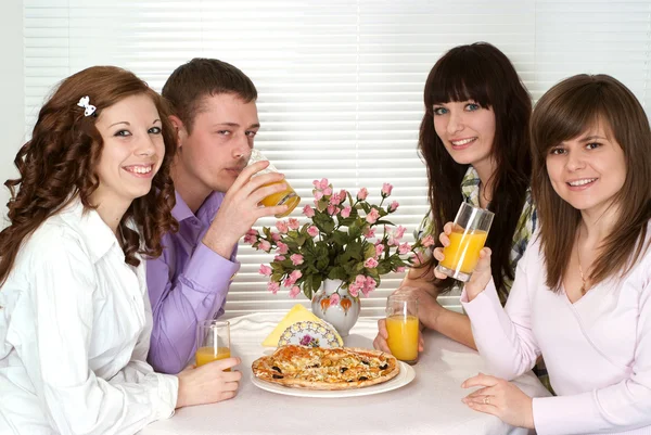 Buen grupo caucásico de cuatro con pizza y jugo sentado — Foto de Stock