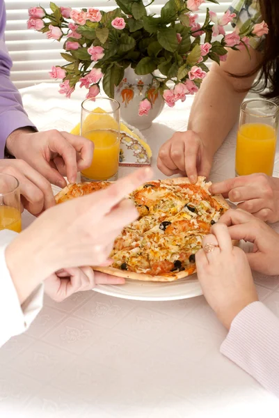 Kaukasiska gruppen av fyra med pizza och juice sitter — Stockfoto