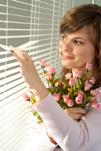 Çiçeklerle duran güzel mutluluk beyaz kadın — Stok fotoğraf