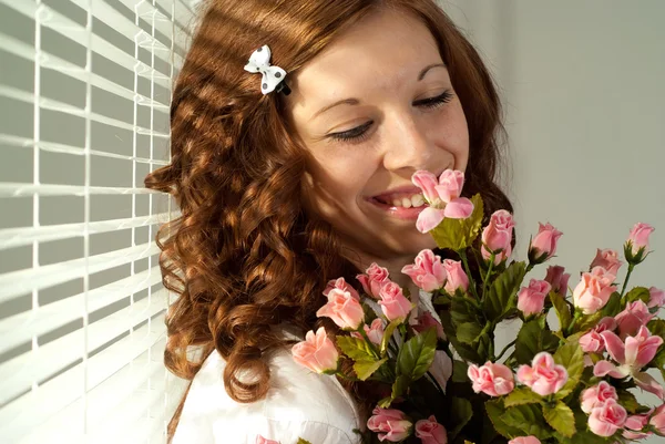 Feliz mujer caucásica de pie con flores — Foto de Stock