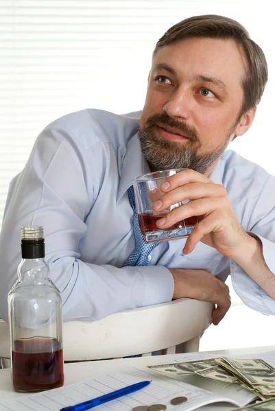 Business man sitting at a table with a bottle and euro — Stock Photo, Image