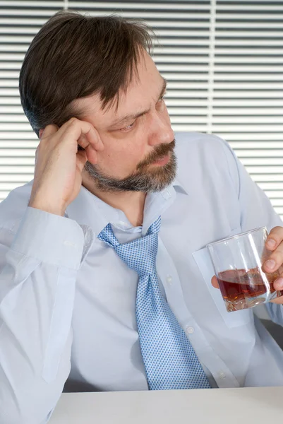 Problems businessman sitting at a table with a bottle — Stock Photo, Image