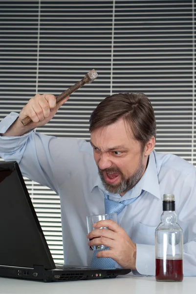 A businessman sits and breaks your computer — Stock Photo, Image