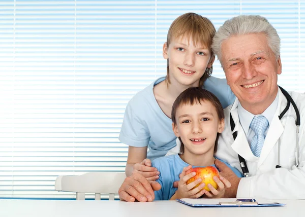Happy good Caucasian doctor with patients — Stock Photo, Image