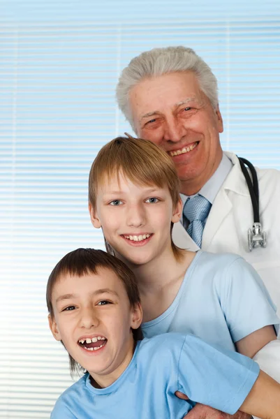 Happy Caucasian good doctor with patients — Stock Photo, Image