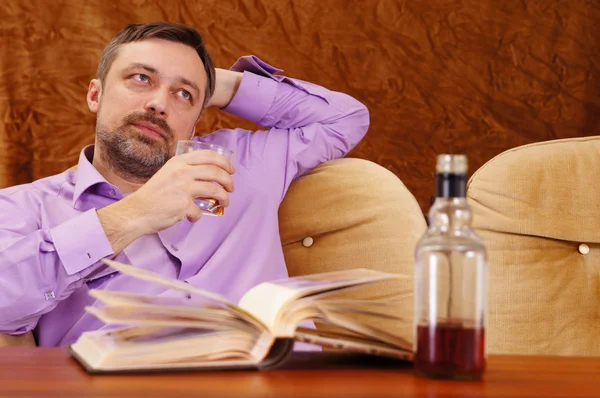 Cute man with whiskey reading — Stock Photo, Image
