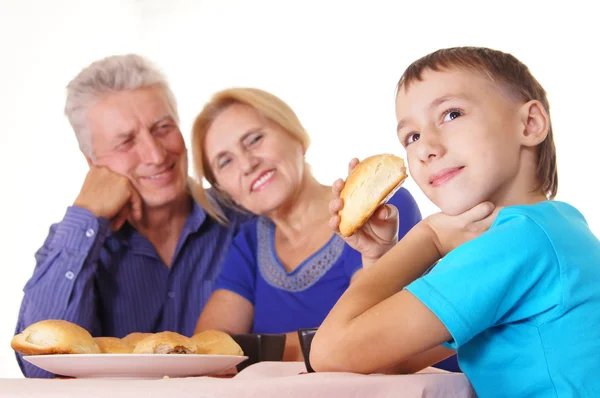 Kid och farföräldrar vid bord — Stockfoto