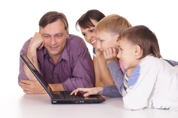 Счастливая семья с ноутбуком — стоковое фото