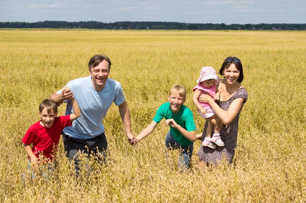 Trevlig familj på fältet — Stockfoto