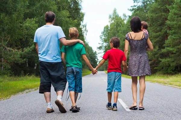 Familia caminando por la carretera — Foto de Stock