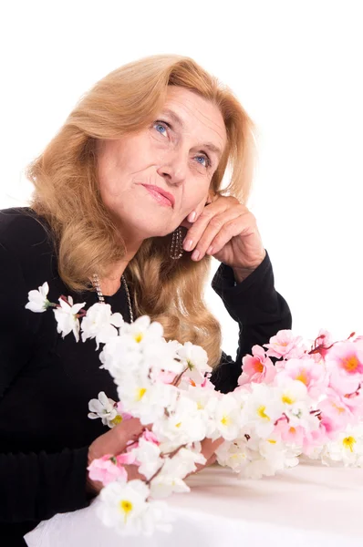 Happy old woman with flowers — Stock Photo, Image