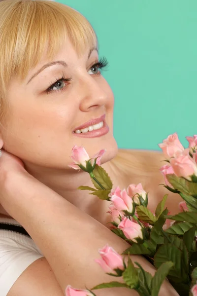 Portret van een gelukkig blonde Kaukasische wijfje met bloemen — Stockfoto
