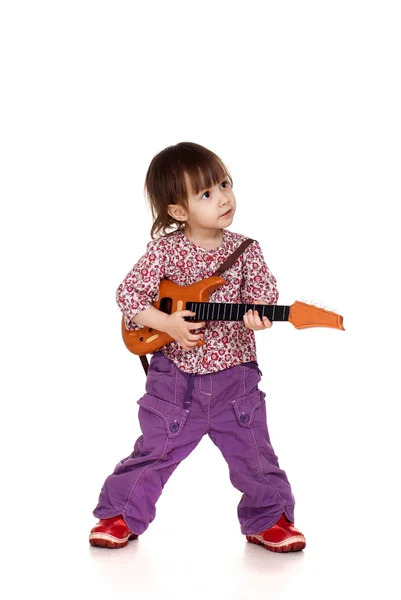 Linda menina caucasiana brinca com uma guitarra — Fotografia de Stock