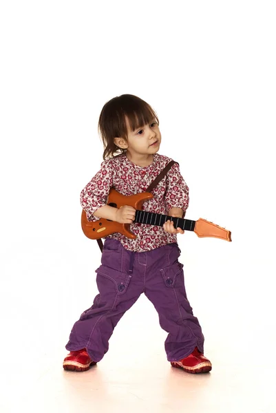 Linda menina caucasiana pouco agradável joga com uma guitarra — Fotografia de Stock