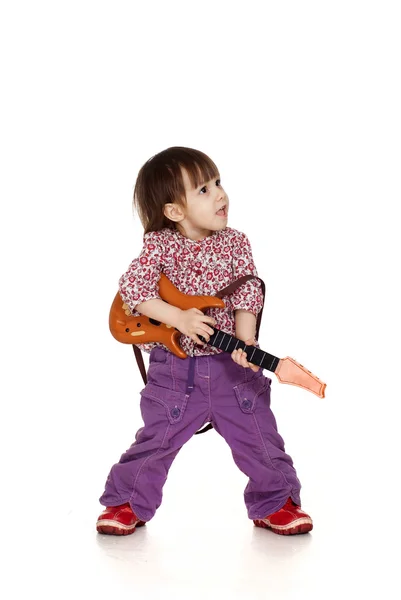 Linda menina caucasiana feliz brinca com uma guitarra — Fotografia de Stock