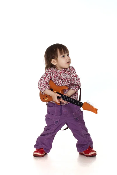Bonita menina caucasiana brinca com uma guitarra — Fotografia de Stock