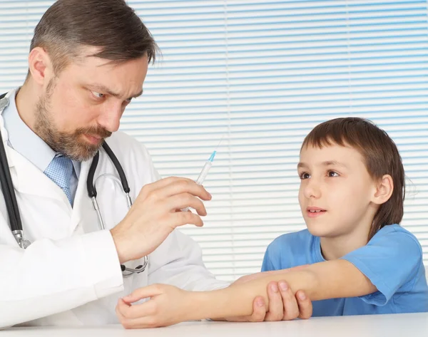 Um belo médico caucasiano adulto com um menino sentado — Fotografia de Stock