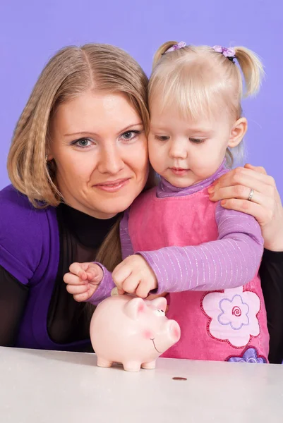 Милая белая мама с дочерью играют с копилкой — стоковое фото