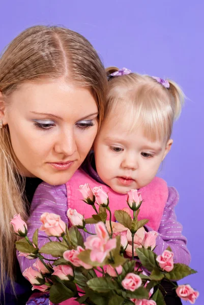 Pretty Caucasian mama and daughter with flowers — Stock Photo, Image