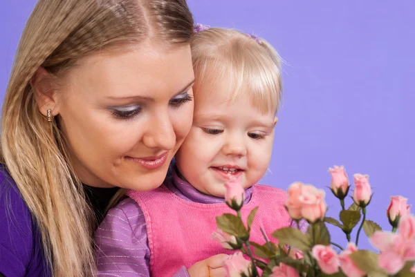 Pretty Caucasian mom and daughter with flowers — Stock Photo, Image