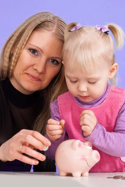 Bastante caucásico madre con su hija jugar con el piggy ba —  Fotos de Stock