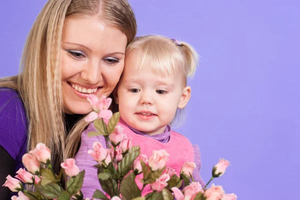 En pen, hvit mor og en søt datter med blomster. – stockfoto
