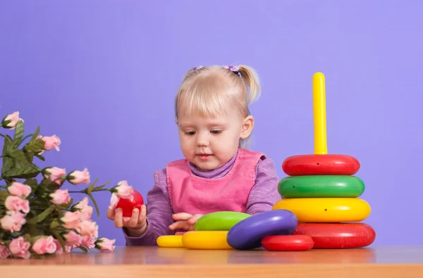 A small charming Caucasian poppet plays with toy — Stock Photo, Image