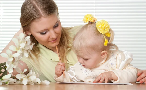 Bir masada oturan güzel beyaz anne ve şans kızı — Stok fotoğraf