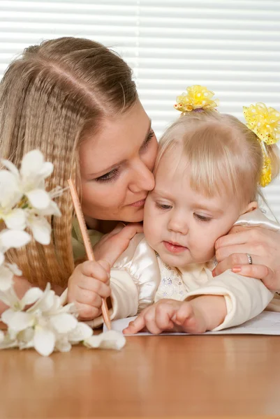 Mooie Kaukasische moeder en geluk dochter zitten aan een tafel — Stockfoto