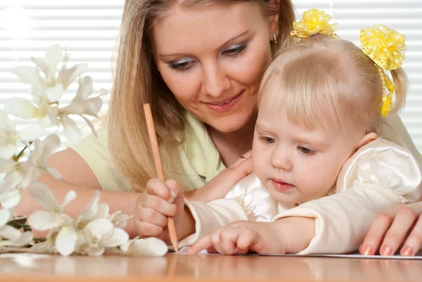 Красиві кавказьких матері і щастить дочка сидить за столом — стокове фото