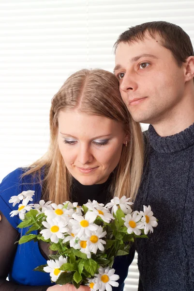 Glad trevlig kaukasisk par med blommor står — Stockfoto