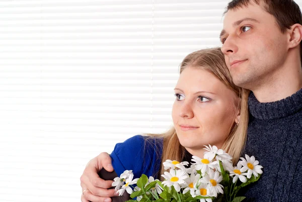 Happy good Caucasian couple with flowers stands — Stock Photo, Image